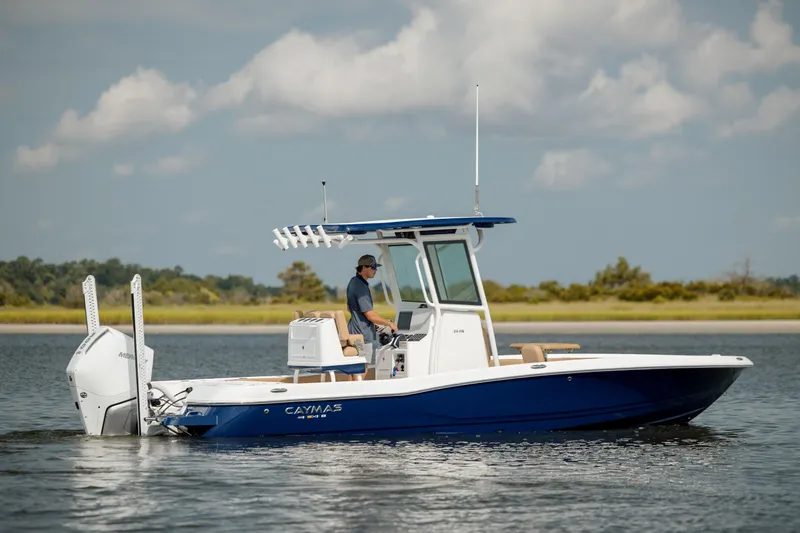 Slide: The Image of 2025 Caymas 26 HB boat cruising on calm water under a cloudy sky. - 4