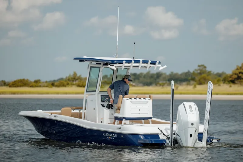 Slide: The Image of 2025 Caymas 26 HB boat cruising on a calm lake with a clear sky. - 9