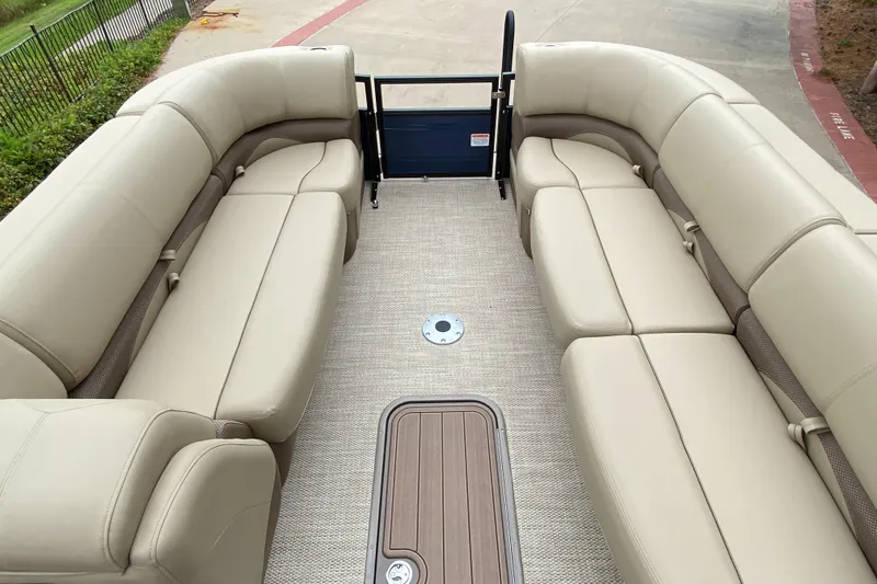 Slide: The Image of 2024 Regency 250 DL3 pontoon boat interior with beige seating and carpeted floor. - 3
