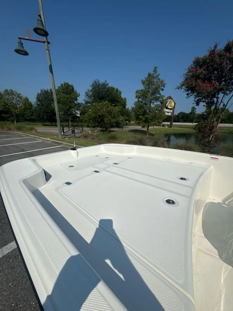 Slide: The Image of 2024 Mako Pro Skiff 17 CC boat in a parking lot, surrounded by trees. - 4