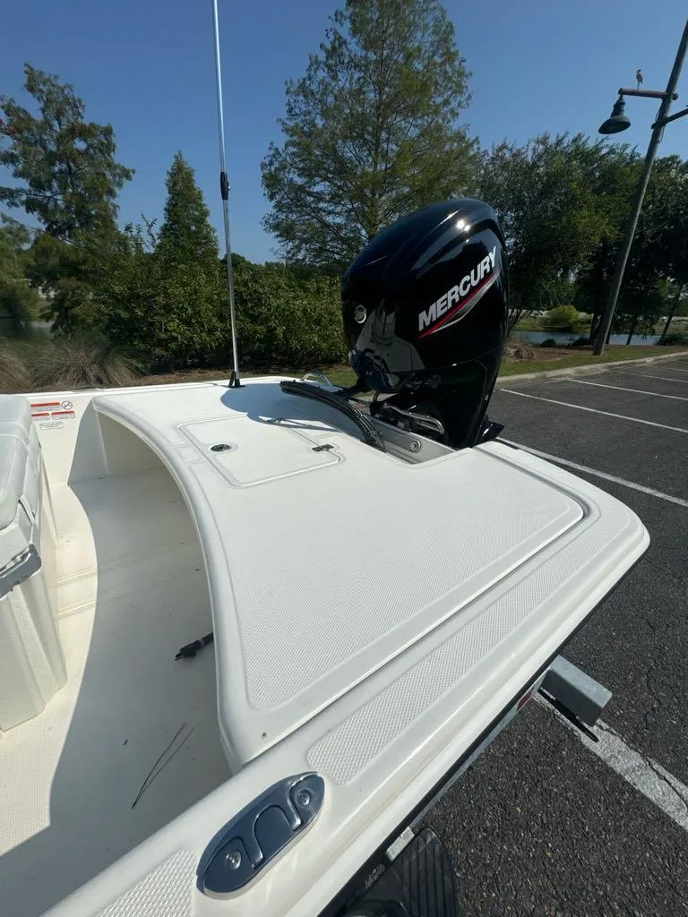 Slide: The Image of 2024 Mako Pro Skiff 17 CC with Mercury outboard motor in a parking lot. - 6