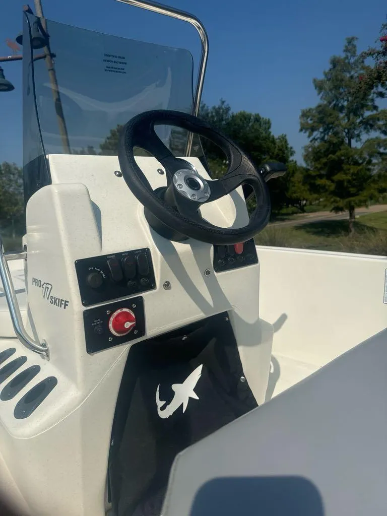 Slide: The Image of 2024 Mako Pro Skiff 17 CC boat console with steering wheel and controls. - 7