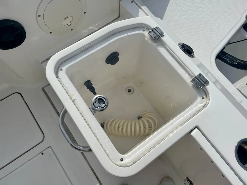 Slide: The Image of 2023 Trophy T24CC boat livewell with coiled hose and latch. - 10