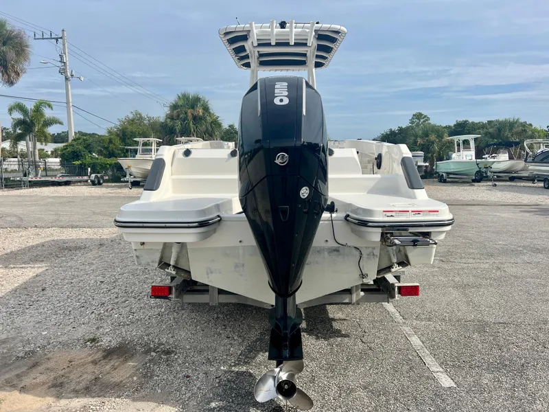 Slide: The Image of 2023 Trophy T24CC boat with powerful outboard motor in a marina setting. - 6