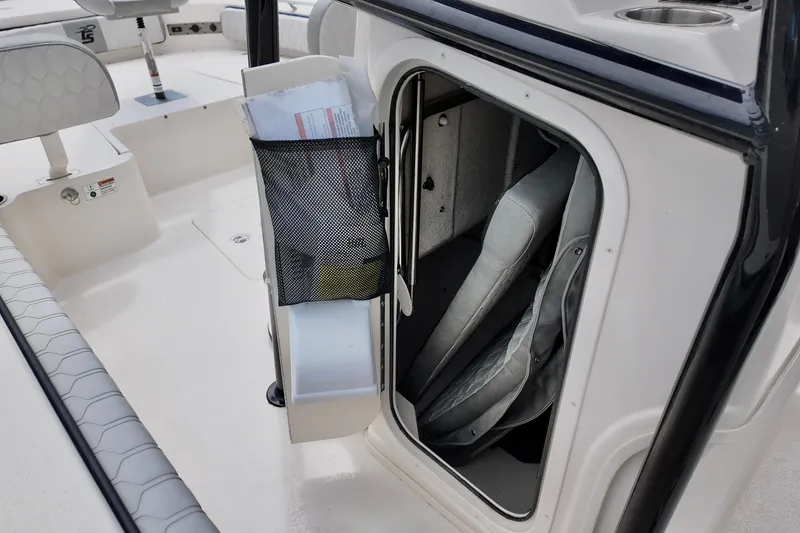 Slide: The Image of 2025 Carolina Skiff 26 Ultra Elite boat storage compartment with seating and mesh pocket. - 10
