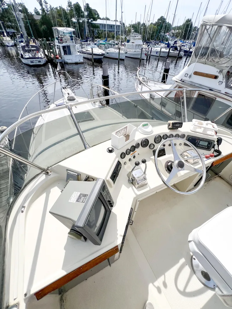 Slide: The Image of 1987 Tollycraft 34 Sport Sedan boat helm with marina view. - 12