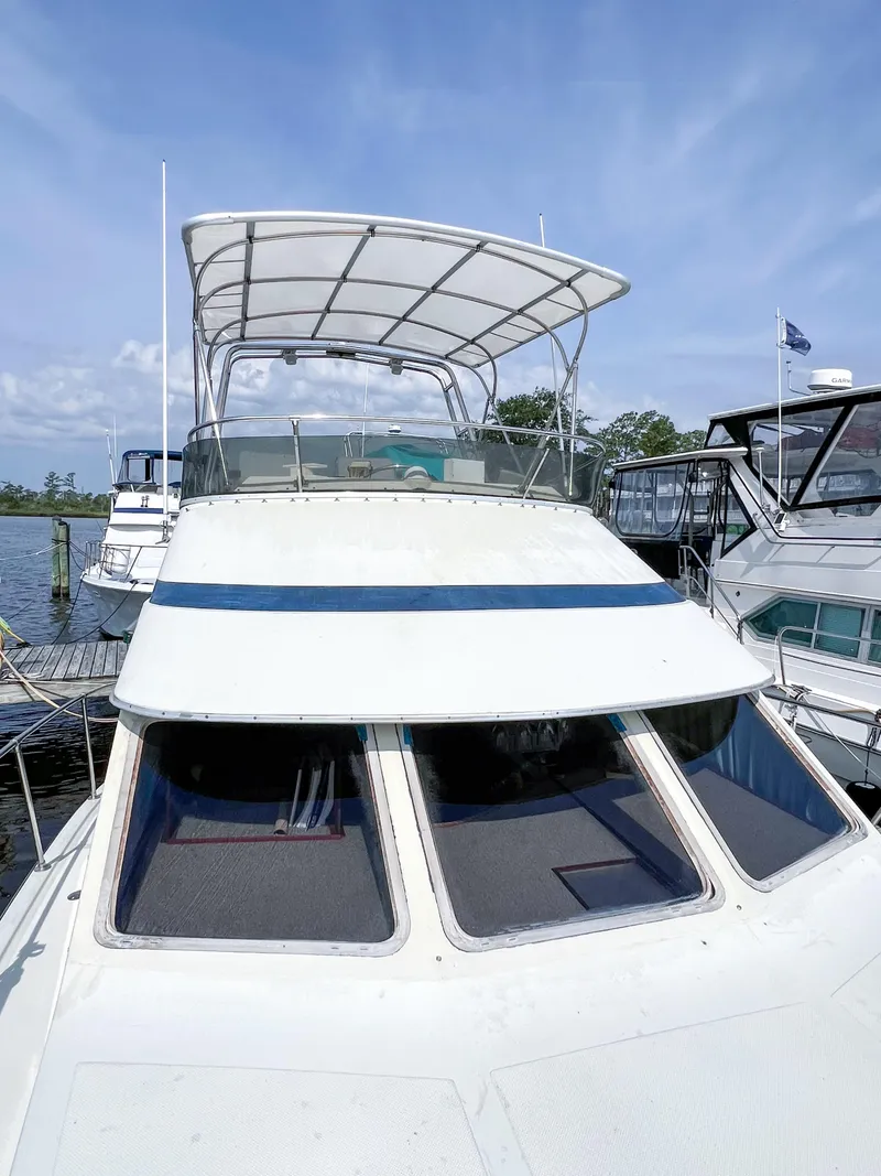 Slide: The Image of 1987 Tollycraft 34 Sport Sedan docked, featuring a spacious flybridge and sleek design. - 19