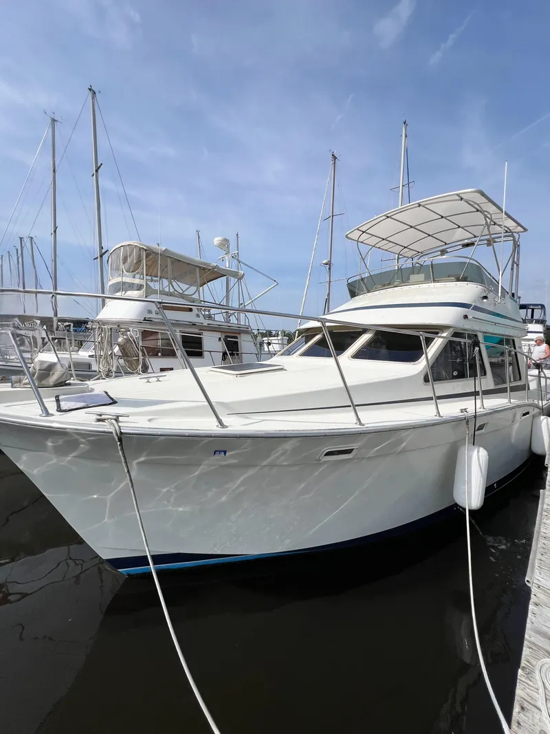 Slide: The Image of 1987 Tollycraft 34 Sport Sedan docked at marina under clear sky. - 2