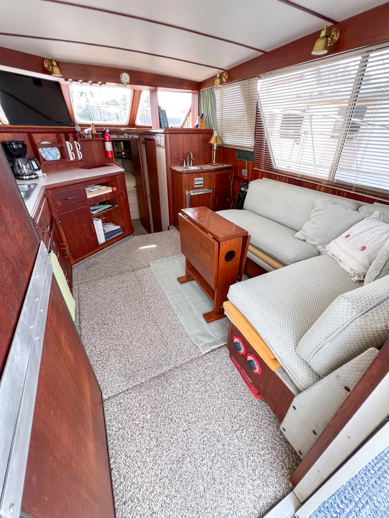 Slide: The Image of 1987 Tollycraft 34 Sport Sedan interior with cozy seating and wooden accents. - 20