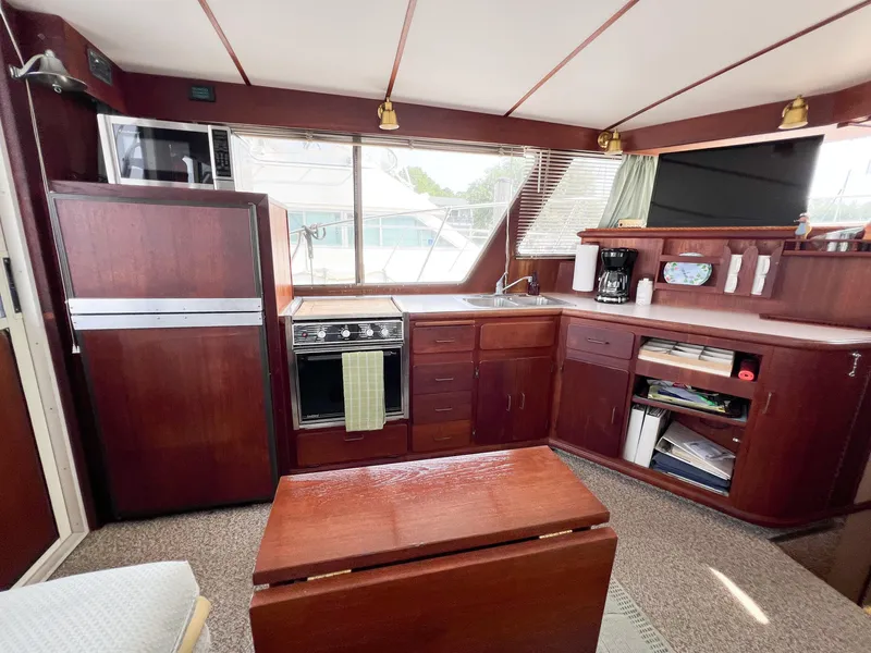 Slide: The Image of Interior of 1987 Tollycraft 34 Sport Sedan with kitchen and wooden cabinetry. - 24