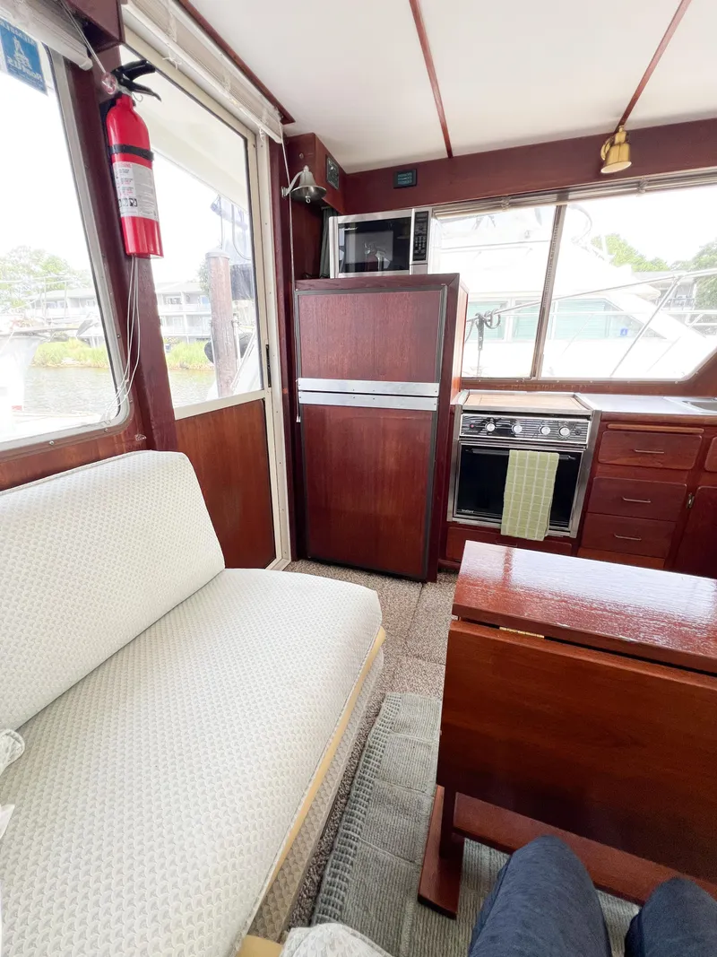Slide: The Image of Interior of 1987 Tollycraft 34 Sport Sedan with seating, kitchen, and appliances. - 25