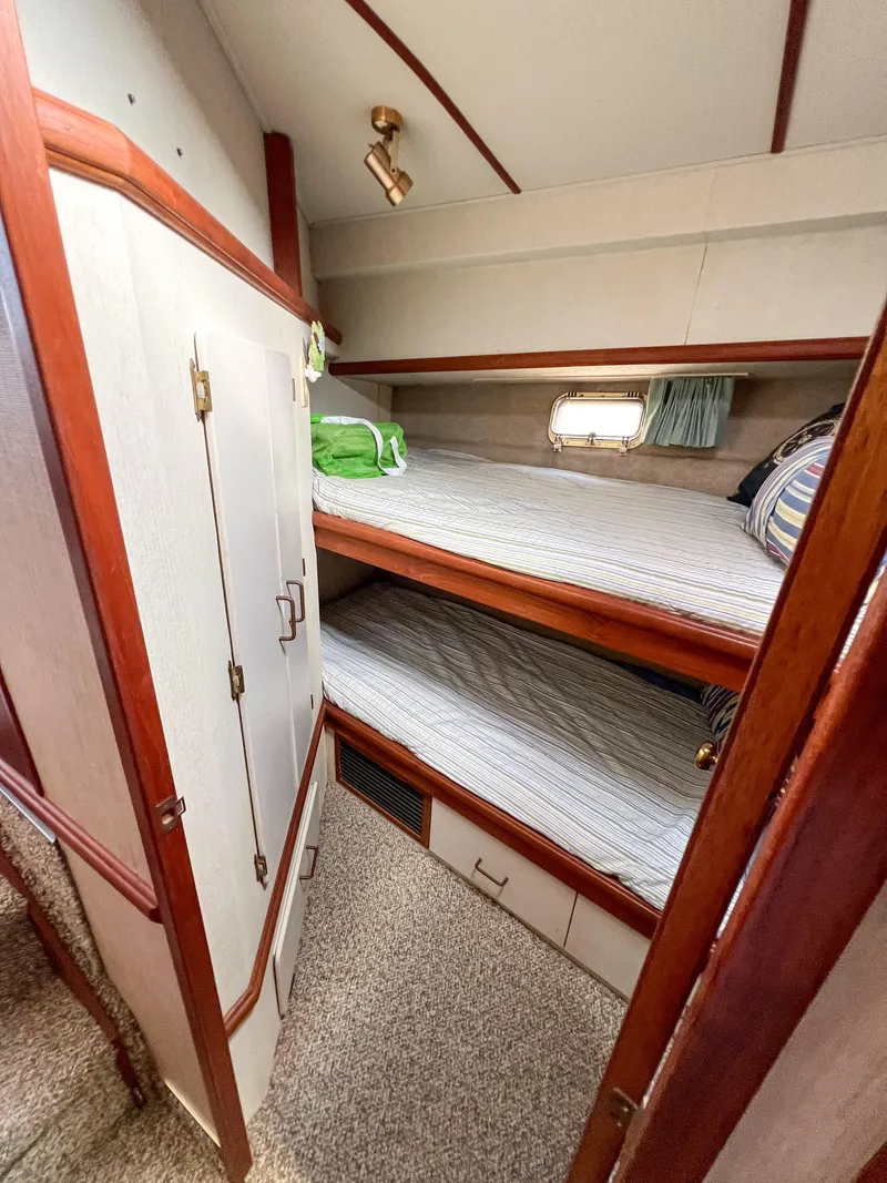 Slide: The Image of 1987 Tollycraft 34 Sport Sedan cabin with bunk beds and wooden cabinetry. - 36