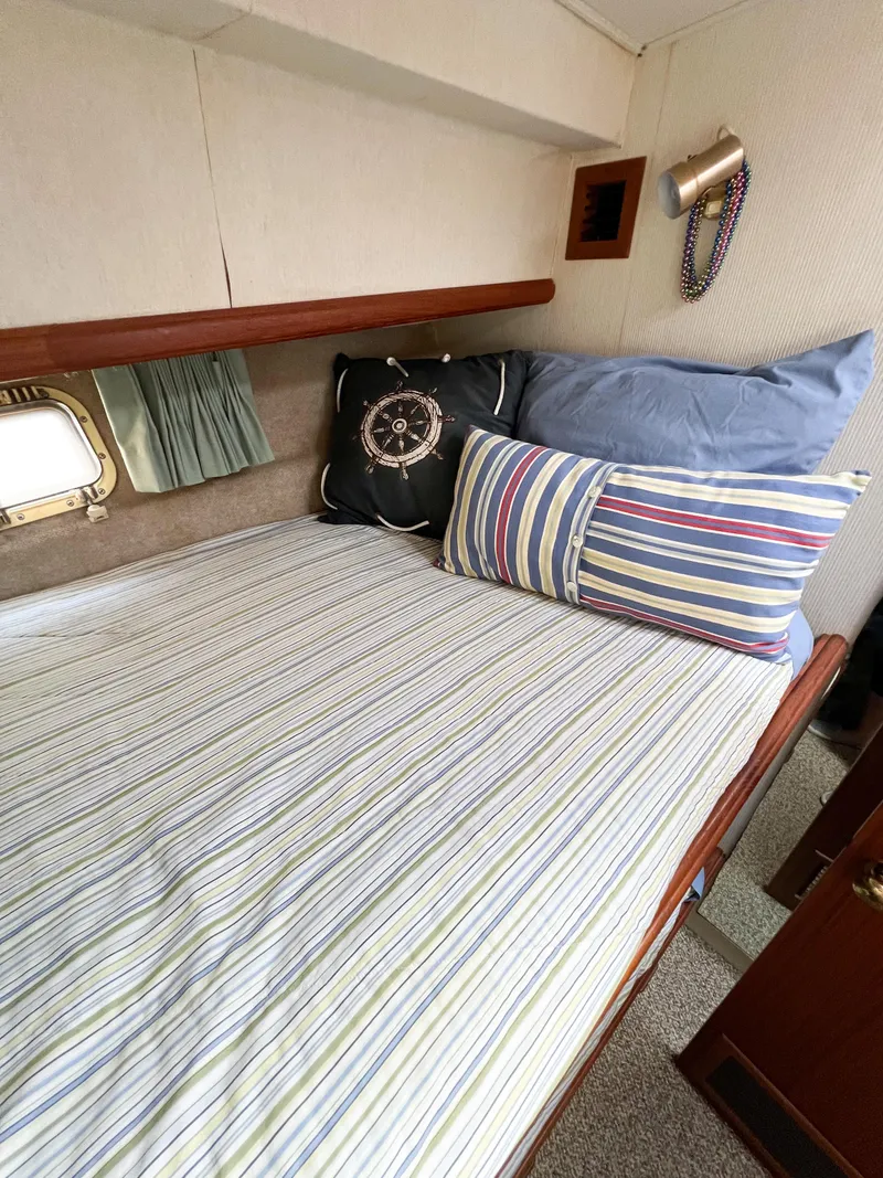 Slide: The Image of Cozy cabin interior of 1987 Tollycraft 34 Sport Sedan with striped bedding and nautical decor. - 38