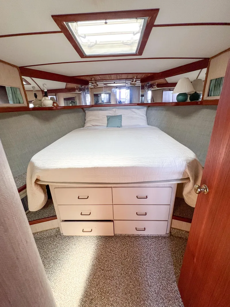 Slide: The Image of 1987 Tollycraft 34 Sport Sedan bedroom with bed, drawers, and skylight. - 41