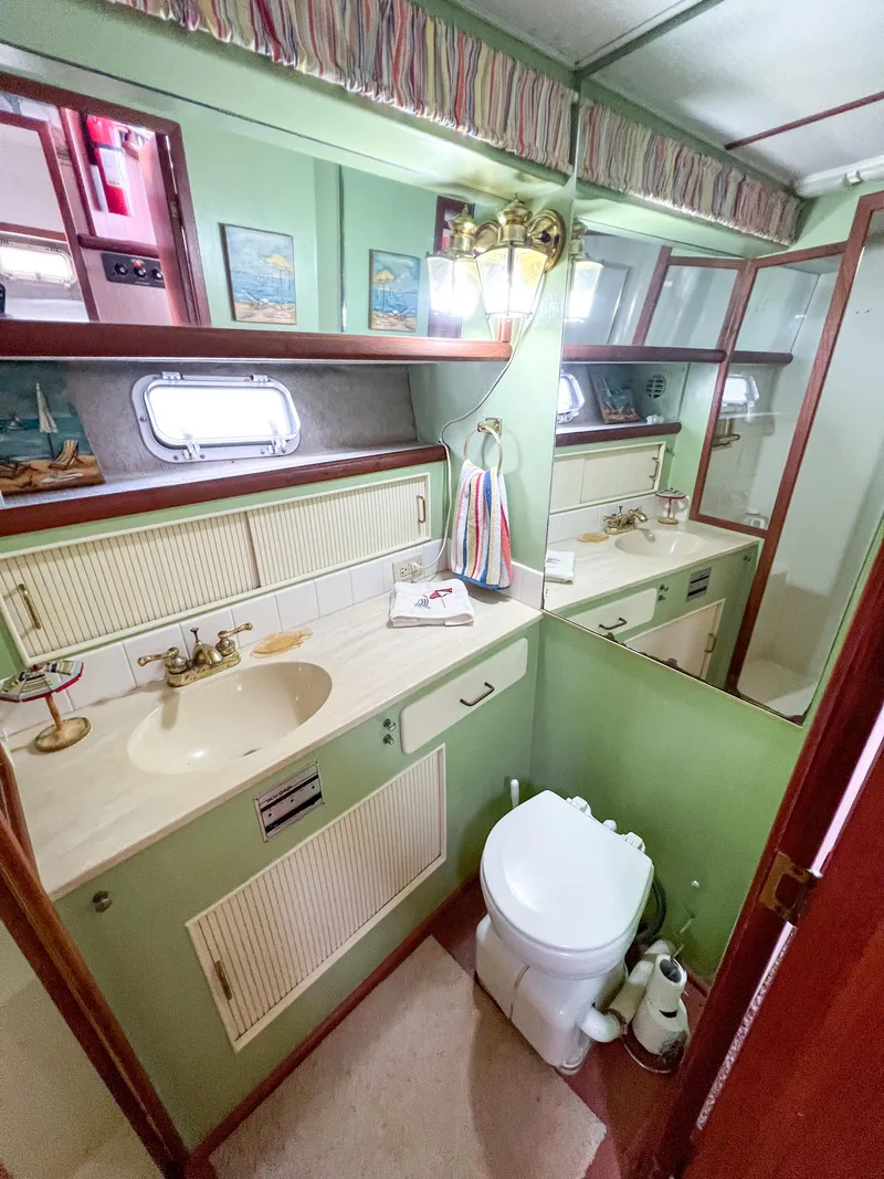 Slide: The Image of 1987 Tollycraft 34 Sport Sedan bathroom with green cabinetry, sink, and toilet. - 42