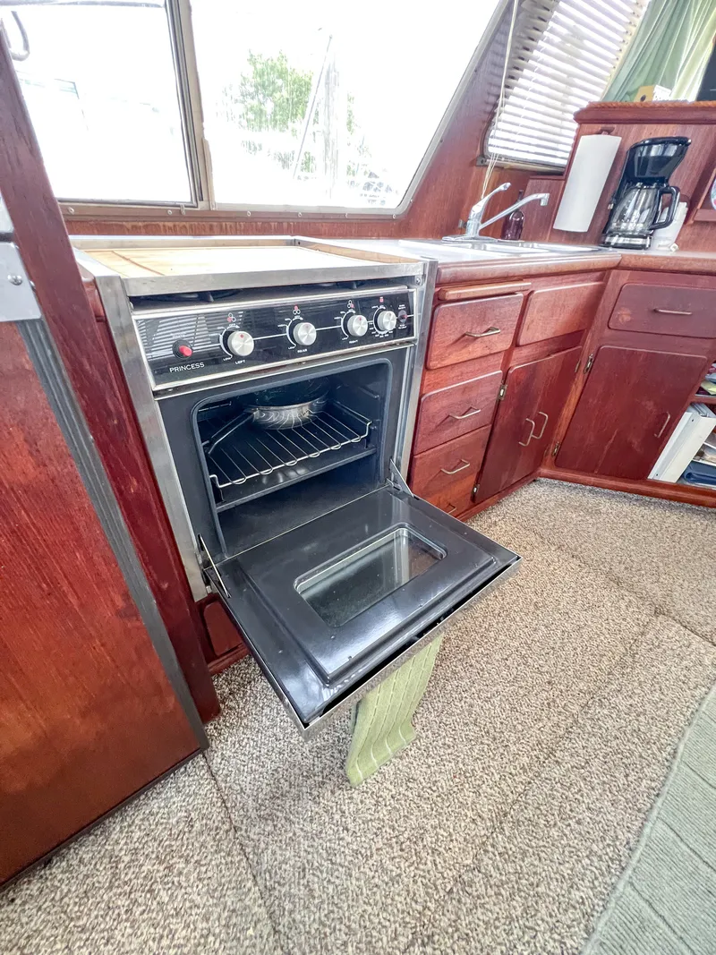 Slide: The Image of 1987 Tollycraft 34 Sport Sedan kitchen with open oven and wooden cabinetry. - 46