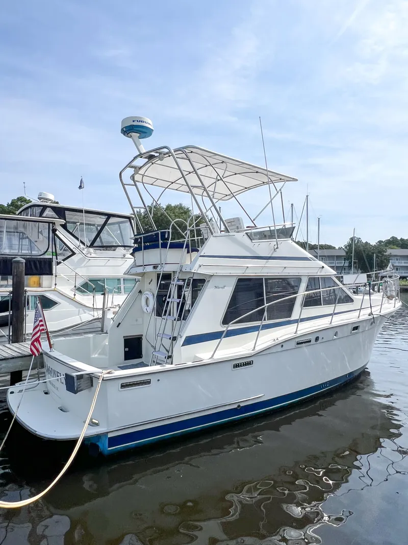 Slide: The Image of 1987 Tollycraft 34 Sport Sedan docked at marina, featuring classic design and spacious deck. - 6