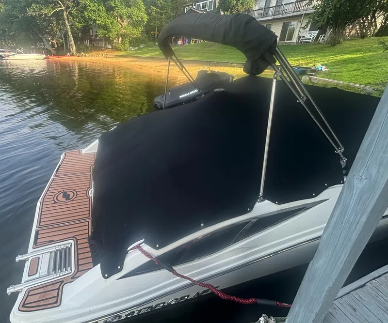 Slide: The Image of 2014 Starcraft SCX 230 boat docked with cover on, near a lakeside. - 12