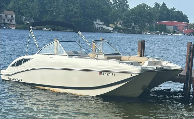 Slide: The Image of 2014 Starcraft SCX 230 boat docked on a scenic lake. - 14