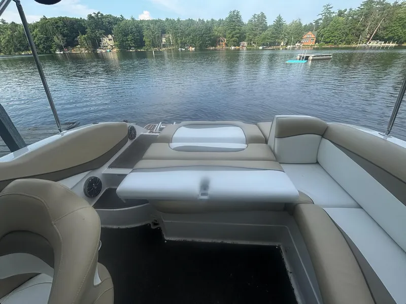 Slide: The Image of 2014 Starcraft SCX 230 boat interior with beige seating on a lake. - 15