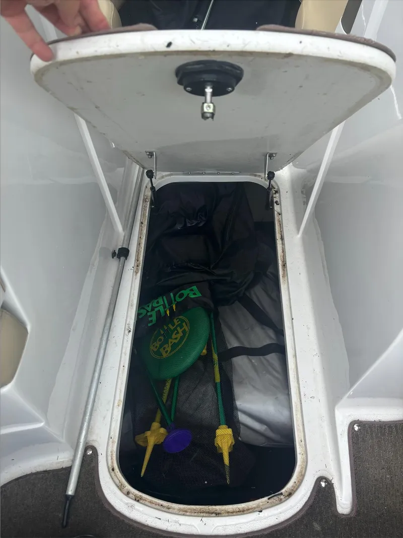 Slide: The Image of Open storage compartment in 2014 Starcraft SCX 230 boat with boating gear inside. - 17