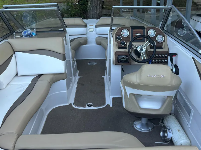 Slide: The Image of 2014 Starcraft SCX 230 boat interior with beige and white seating, steering wheel, and dashboard. - 7