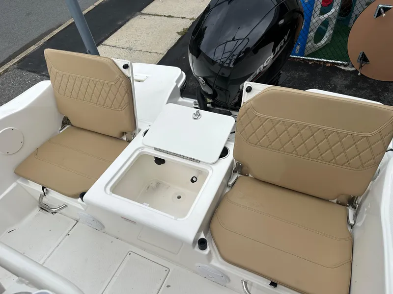 Slide: The Image of 2024 Bayliner Trophy T20CC boat interior with tan seats and storage compartment. - 5
