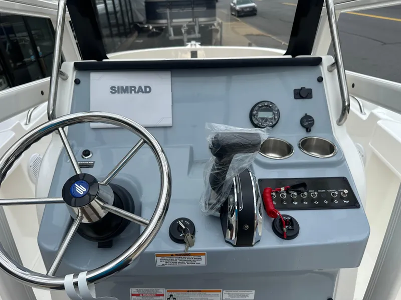 Slide: The Image of 2024 Bayliner Trophy T20CC boat dashboard with steering wheel and controls. - 6
