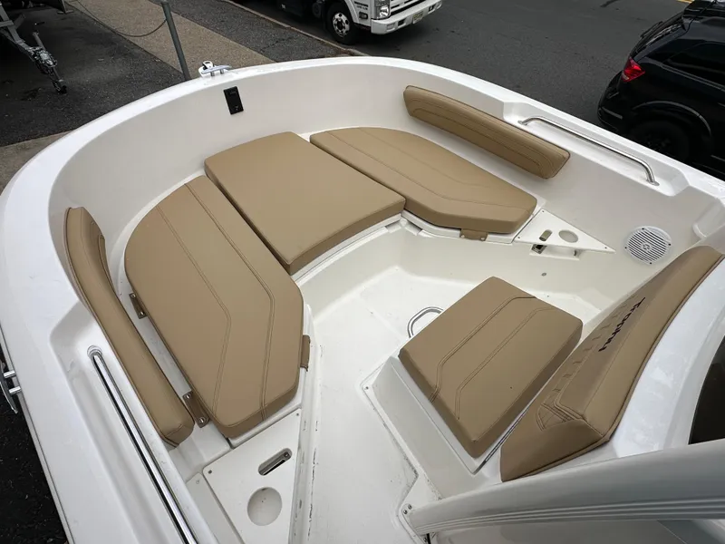 Slide: The Image of 2024 Bayliner Trophy T20CC boat with tan cushioned seating in the bow area. - 9