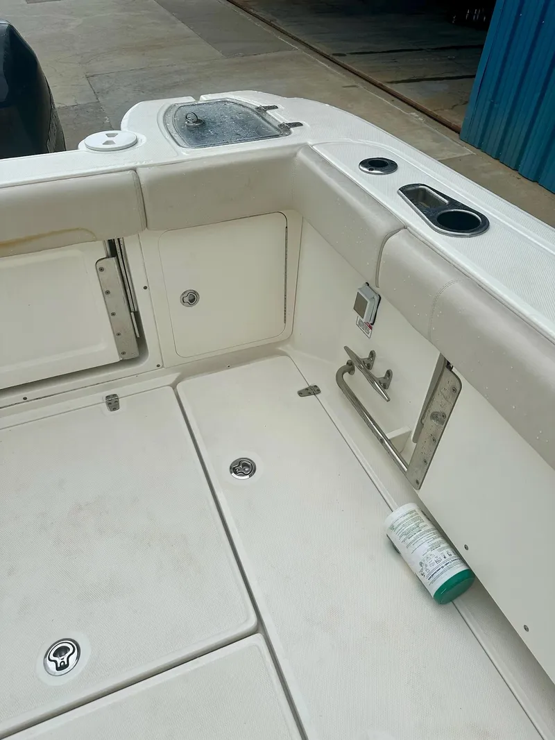 Slide: The Image of 2016 Boston Whaler 315 Conquest boat deck with storage compartments and cup holders. - 12