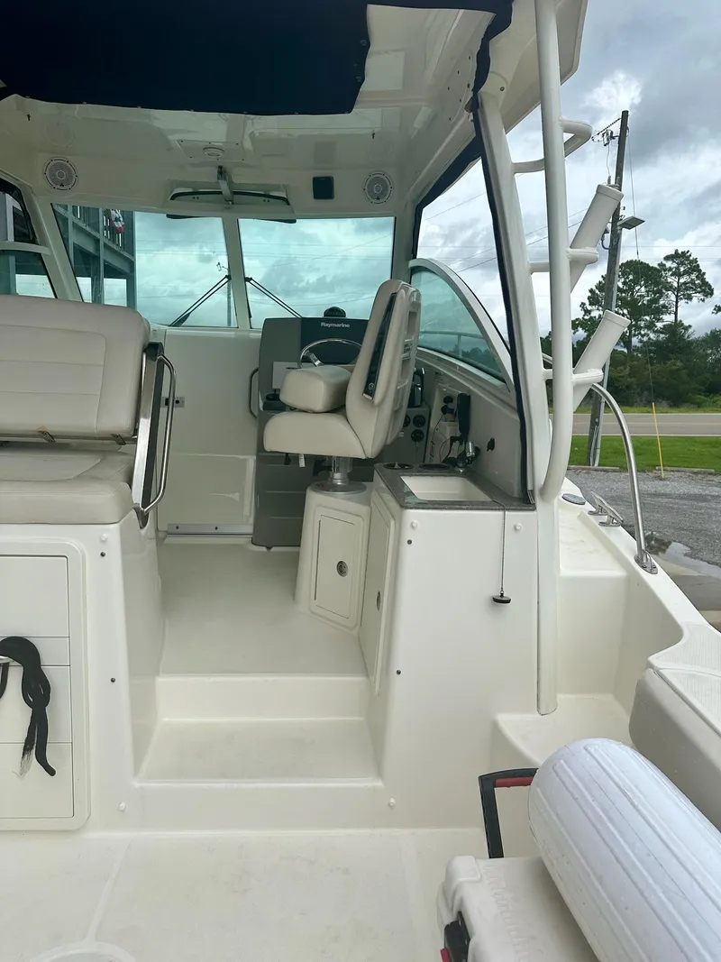Slide: The Image of 2016 Boston Whaler 315 Conquest interior with helm and seating area. - 14