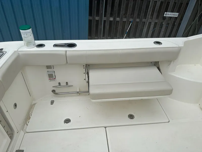 Slide: The Image of 2016 Boston Whaler 315 Conquest boat interior with foldable seat and cup holders. - 17