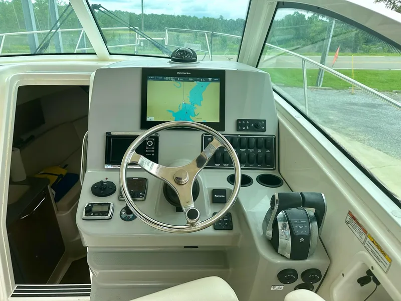 Slide: The Image of 2016 Boston Whaler 315 Conquest helm with navigation display and controls. - 22
