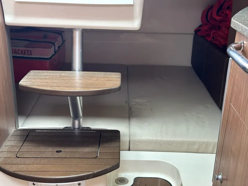 Slide: The Image of Interior cabin of 2016 Boston Whaler 315 Conquest with wooden steps and seating area. - 28