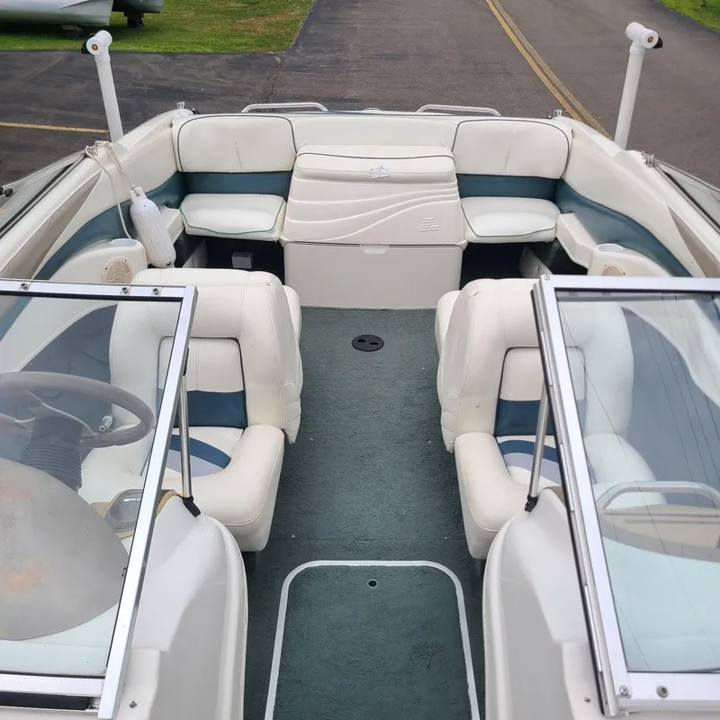 Slide: The Image of Interior of a 1999 Larson 206 boat with white and blue seating. - 10