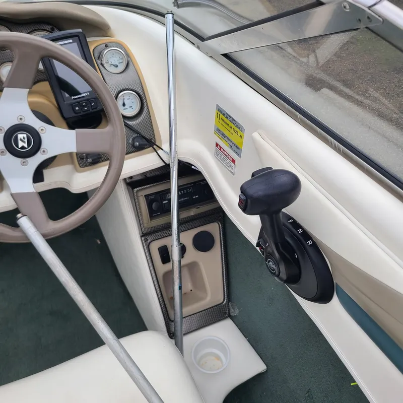 Slide: The Image of 1999 Larson 206 boat cockpit with steering wheel and control panel. - 12