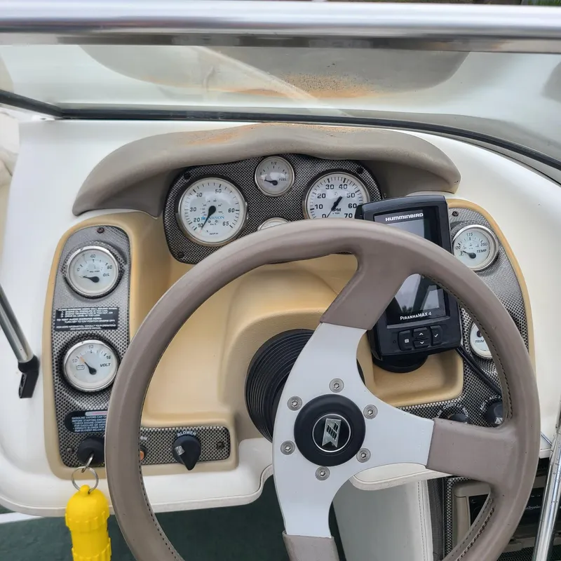 Slide: The Image of 1999 Larson 206 boat dashboard with steering wheel and gauges. - 13