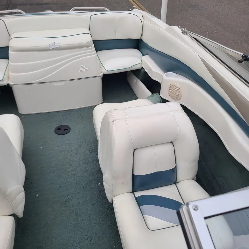 Slide: The Image of Interior of a 1999 Larson 206 boat with white and blue seating. - 8