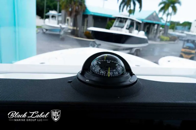 Slide: The Image of Compass on 2025 Sea Fox 228 Commander Center Console, with boats and palm trees in background. - 17