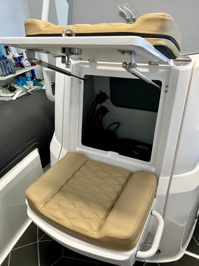 Slide: The Image of 2024 Highfield SP 600 RIB seat with storage compartment open, showcasing beige cushioning. - 10