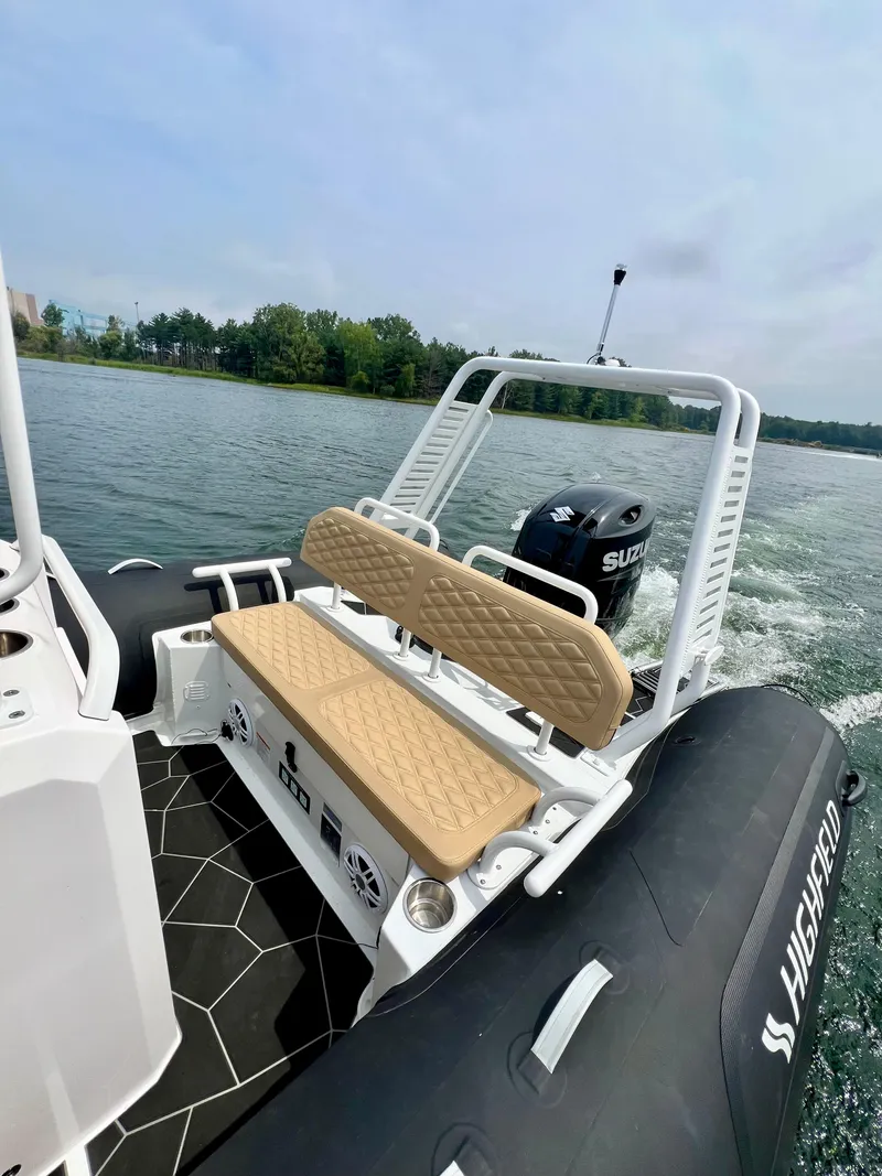 Slide: The Image of 2024 Highfield SP 600 RIB on water, featuring tan seating and Suzuki outboard motor. - 17