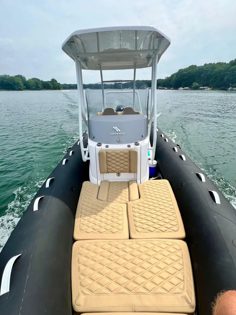 Slide: The Image of 2024 Highfield SP 600 RIB on water, featuring tan cushioned seating and sleek design. - 20