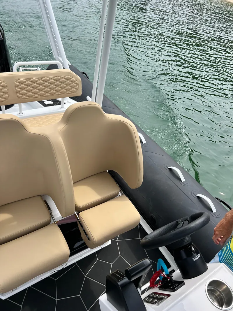 Slide: The Image of 2024 Highfield SP 600 RIB boat interior with beige seating and steering wheel. - 25
