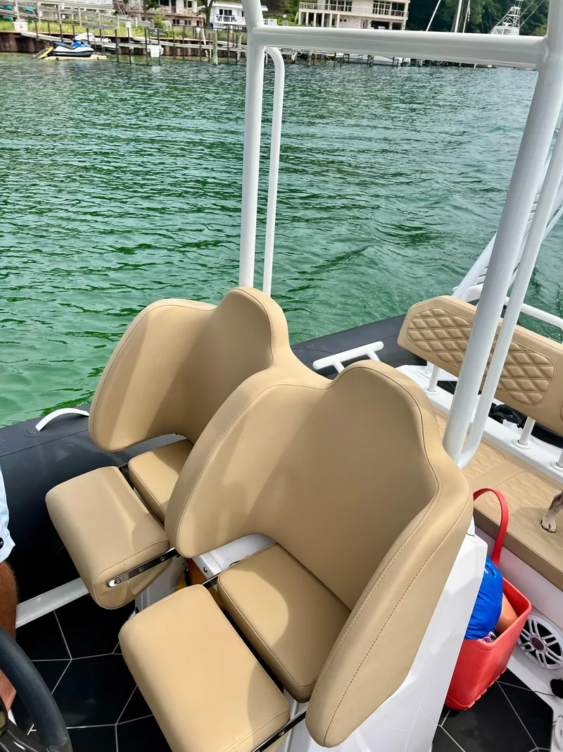 Slide: The Image of 2024 Highfield SP 600 RIB boat seats with beige upholstery on a calm lake. - 27
