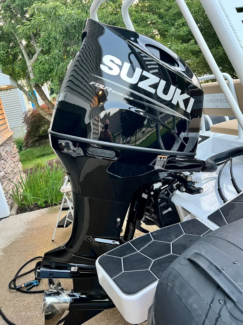 Slide: The Image of 2024 Highfield SP 600 RIB with Suzuki outboard motor, parked outdoors. - 5