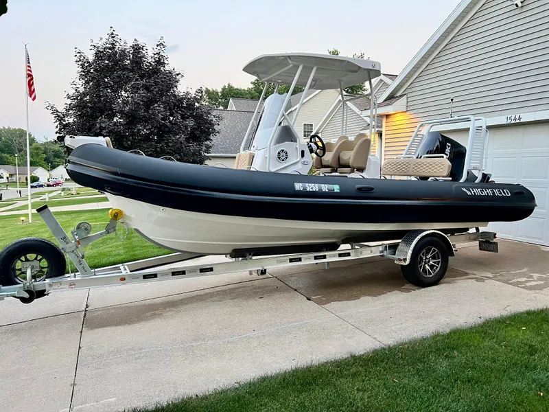 Slide: The Image of 2024 Highfield SP 600 RIB boat on trailer in residential driveway. - 7