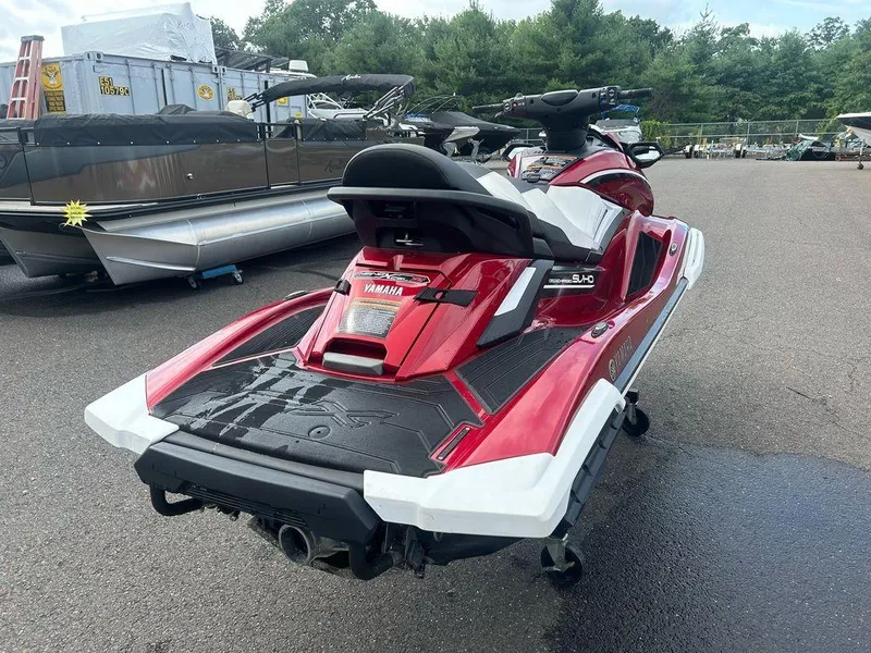 Slide: The Image of 2019 Yamaha WaveRunner FX SVHO in red, parked outdoors near other boats. - 6