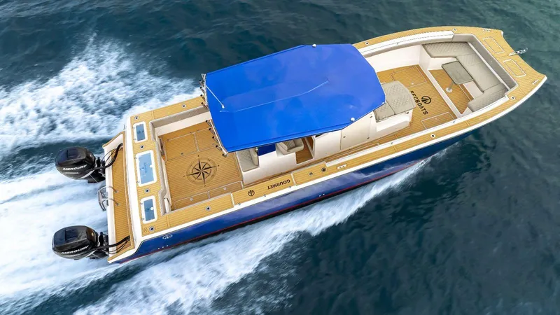 Slide: The Image of Custom Catamaran Sec CatFish 39, 2023 model, cruising on water with blue canopy. - 1