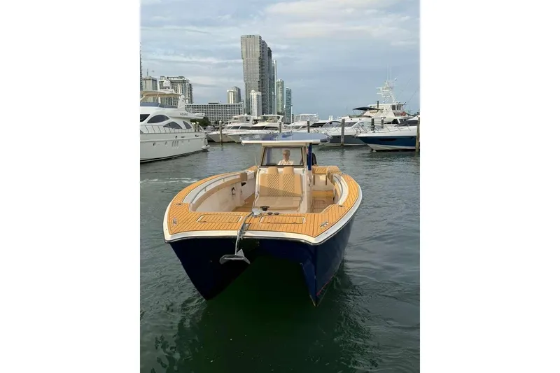 Slide: The Image of 2024 Custom Catamaran SET CAT docked in marina, city skyline in background. - 105