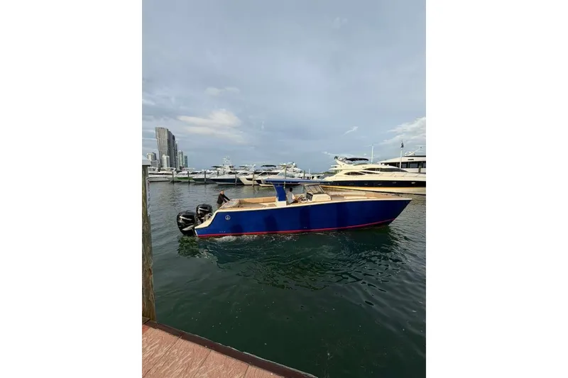 Slide: The Image of 2024 Custom Catamaran SET CAT in marina, blue hull, city skyline background. - 109